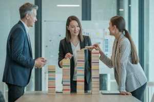 Pracownicy układają kolorowe klocki objaśniając składniki paska wypłaty