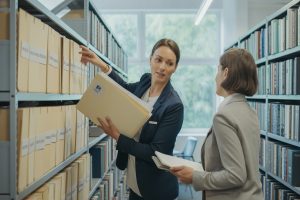 Pracownik odbiera teczkę z archiwum firmowym jako dowód niewypłaconego urlopu